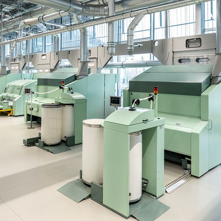 Card at the Rieter Spin Center in Winterthur Interior view of the Spin Center at the Rieter Innovation Center in Winterthur, Switzerland. In the foreground, a Rieter expert checks the settings of a card.