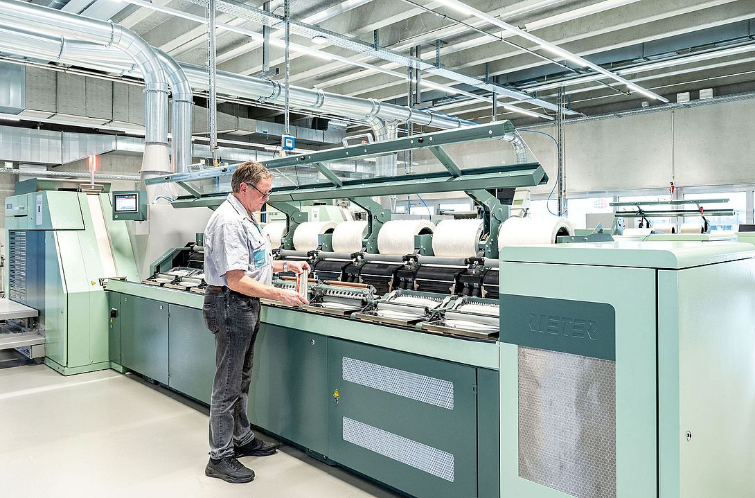 Combing machine at the Rieter Spin Center in Winterthur Interior view of the Spin Center at the Rieter Innovation Center in Winterthur, Switzerland. In the foreground, a Rieter expert works on a comber.