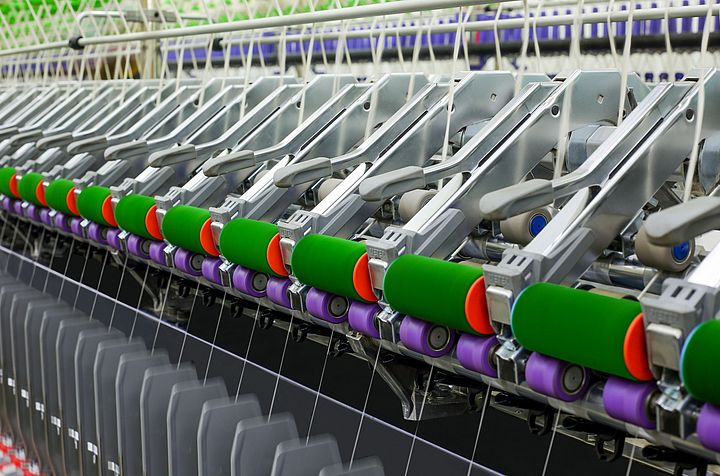 Guiding arm working with a uniform load across the length of the ring spinning machine