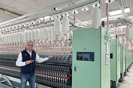 Jordi Ayguasenosa, Manufacturing Director bei Aztlán Textil und Azul Textil, steht neben den Ringspinnmaschinen G 37, die mit COMPACTeasy ausgestattet wurden.