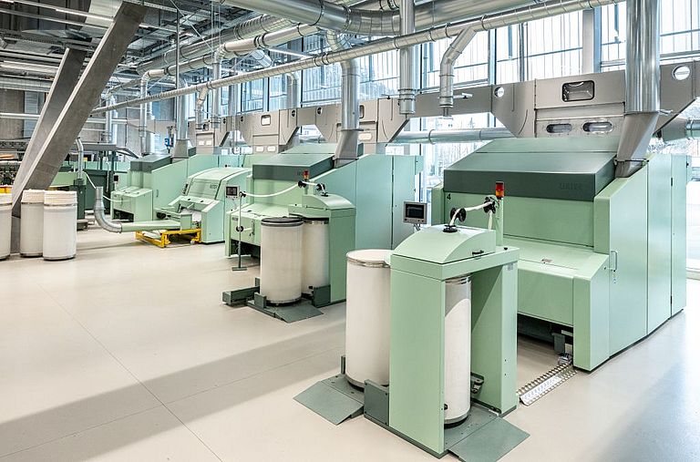 Card at the Rieter Spin Center in Winterthur Interior view of the Spin Center at the Rieter Innovation Center in Winterthur, Switzerland. In the foreground, a Rieter expert checks the settings of a card.