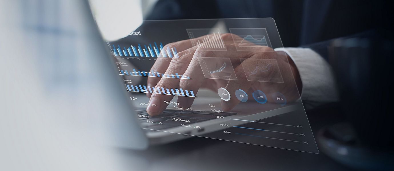 Symbol: Business person studying a financial report on a laptop computer