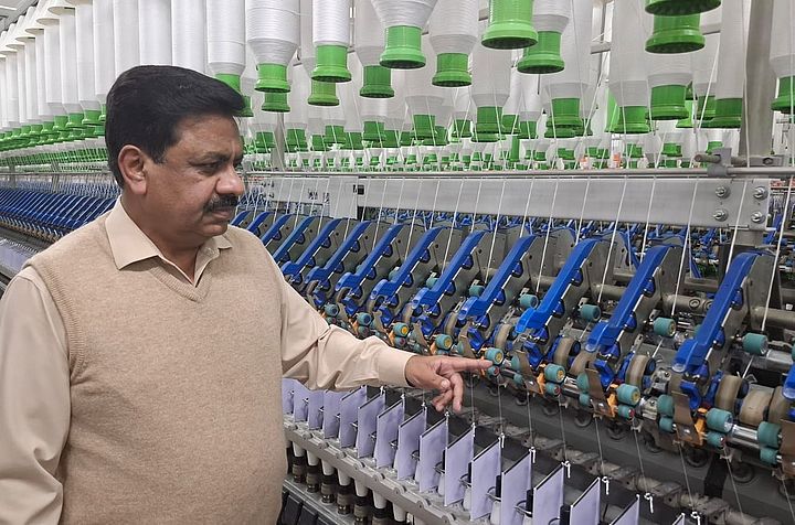 Verbesserte Garnqualität. Gleicher Energieverbrauch. Das ist COMPACTeasy – die erste Wahl von Tariq Nazir, Ibrahim Fibres Limited. Tariq Nazir steht vor einer Kompaktspinnmaschine bei Ibrahim Fibres Limited.