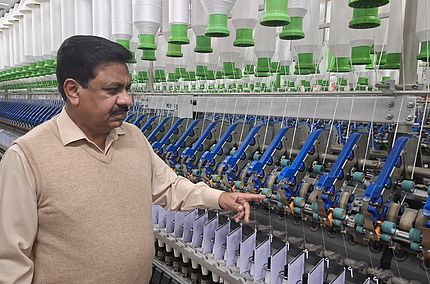 Verbesserte Garnqualität. Gleicher Energieverbrauch. Das ist COMPACTeasy – die erste Wahl von Tariq Nazir, Ibrahim Fibres Limited. Tariq Nazir steht vor einer Kompaktspinnmaschine bei Ibrahim Fibres Limited.