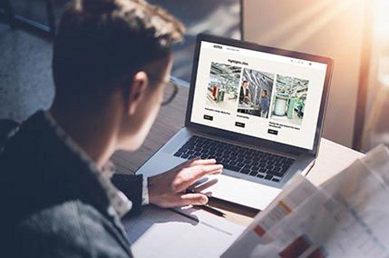 Symbol: Financial analyst browsing through Rieter's Annual Report 2024 on a laptop computer..