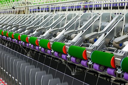 Guiding arm working with a uniform load across the length of the ring spinning machine