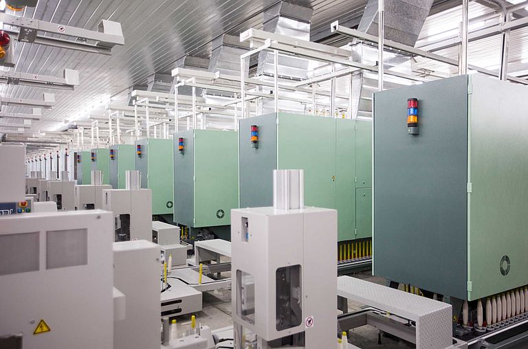 Many ring spinning machines in a spinning mill connected to a winding machine by means of automatic cop transport system