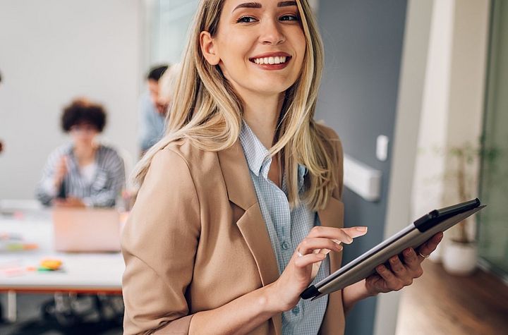 Happy white collar worker holding a tablet